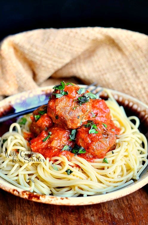 spaghetti and meatballs with sauce on a plate 