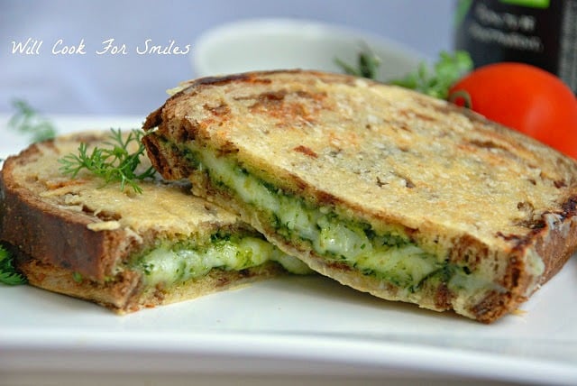 Parmesan Crusted Pesto Grilled Cheese cut in half on a white plate 