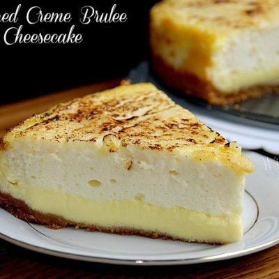 1slice of creme brulee cheesecake on a white plate in front of the rest of the cake in background to the right