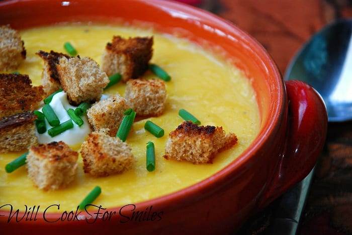 Potato Butternut Squash Soup in a bowl with crotons, sour cream, and chives 