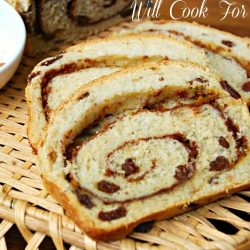 2 slices of pumpkin spice swirl bread on a wicker tray with a small white bowl of cinnamon to the left