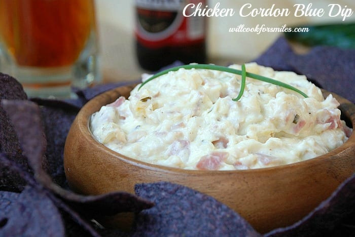 Chicken Cordon Bleu Dip Recipe in a wood bowl with purple chips around it 