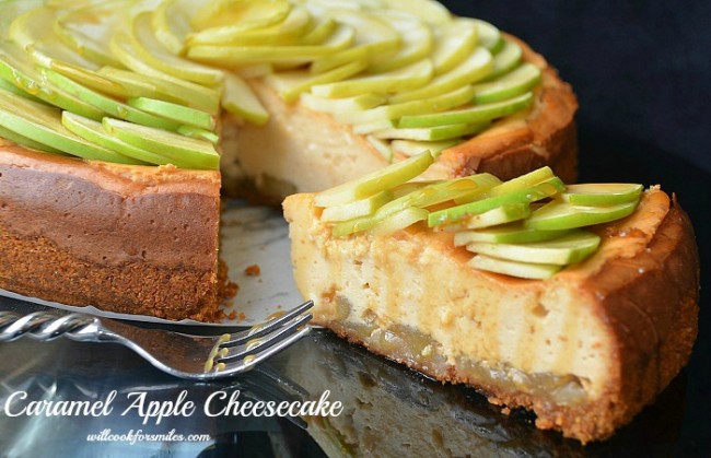 apple cheesecake on a table with a slice slightly out of the rest of the cheesecake and a fork to the left 