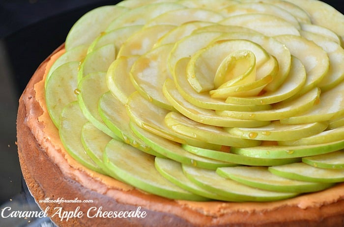 horizonal photo of whole cheesecake with apples on top 