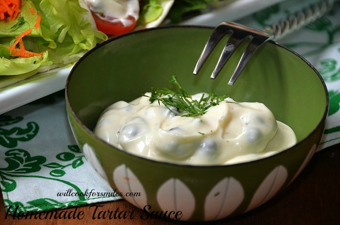  tartar sauce in a bowl with dill on top with a fork over it 