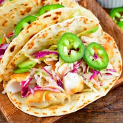 one fish taco topped with colorful slaw and jalapenos.
