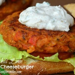 2 chili lime burgers on buns with creamy topping on wood cutting board