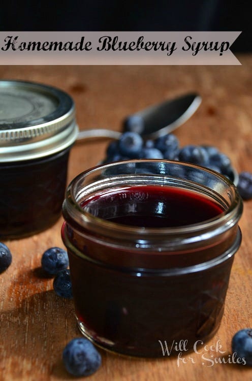 blueberry syrup in a small mason jar on a wood table 