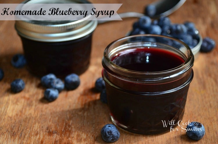 blueberry syrup in a small mason jar on a wood table 