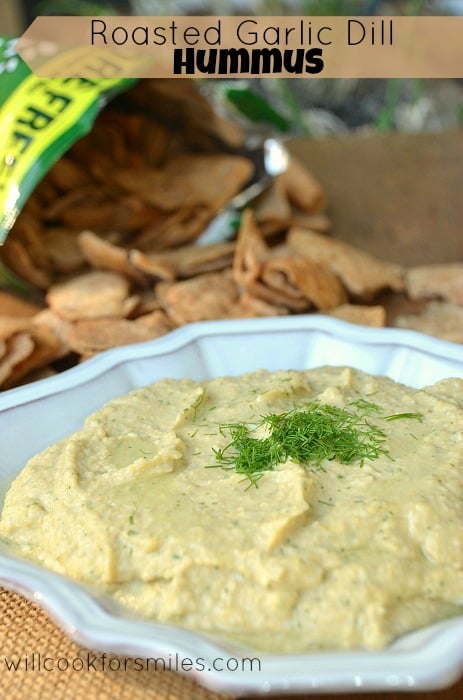 Roasted Garlic Dill Hummus in a blue bowl with dill on top for garnish 