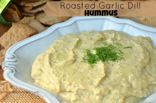 Roasted Garlic Dill Hummus in a blue bowl with dill on top for garnish 