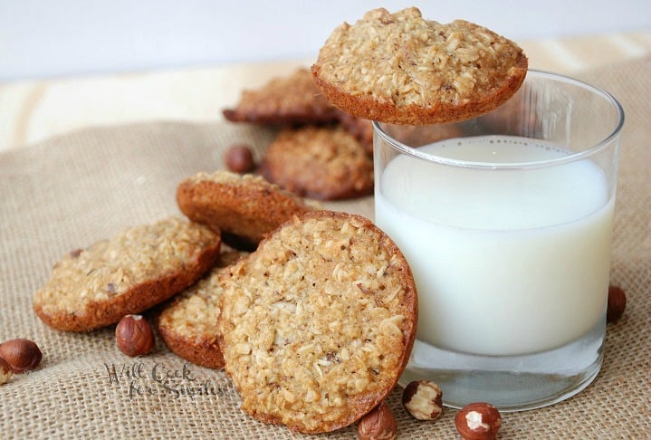 cookies on a piece of burlap with a glass of milk with a cookie on the edge 