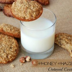 top view of cookies piled on burlap cloth with glass of milk in center of shot