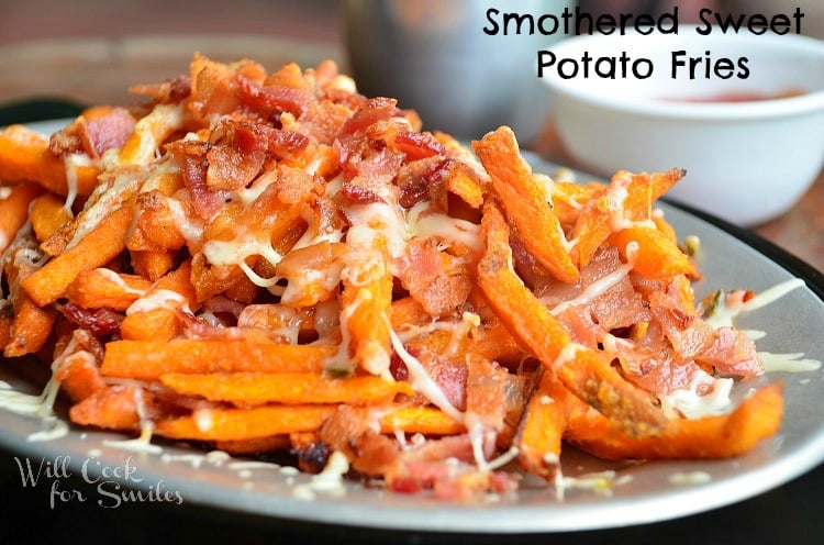 close up shot of smothered sweet potato fries with white sauce cup to right in background