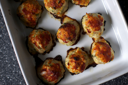 baked meatballs in a white casserole dish 