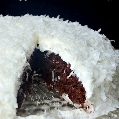 shot from front whole cake with 1 slice removed from front on glass plate
