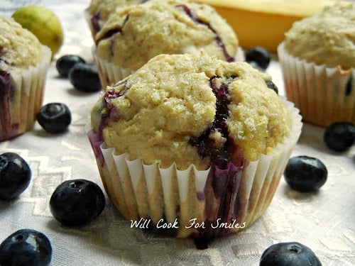 blue berry muffins on a table with blueberries around it 