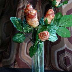 front shot of edible flowers made of bacon in a clear glass vase