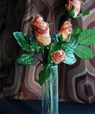 front shot of edible flowers made of bacon in a clear glass vase