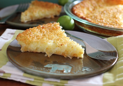 Key lime coconut pie slice on a plate with a fork to the right 