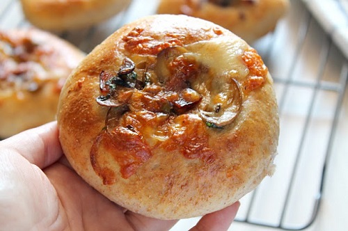 bacon mushroom pastry held in hand with additional pastries in background