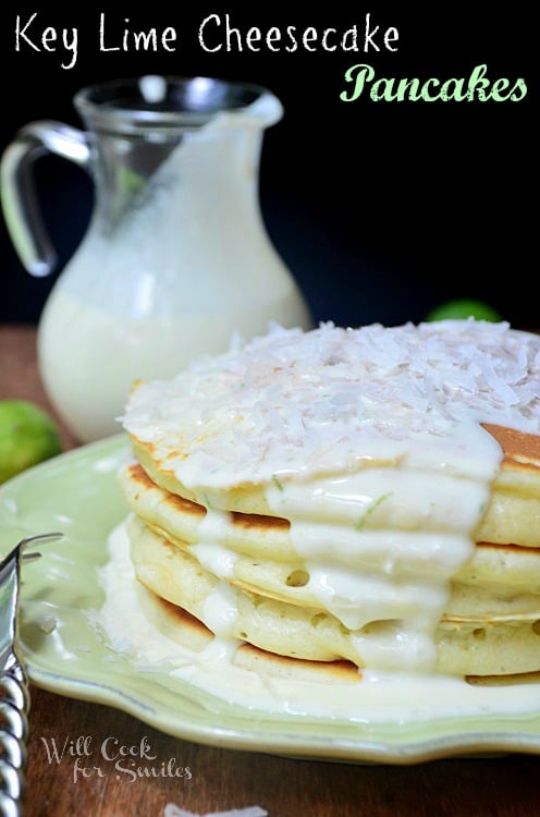 Key lime cheesecake pancakes on a plate with coconut on top of them and homemade syrup 