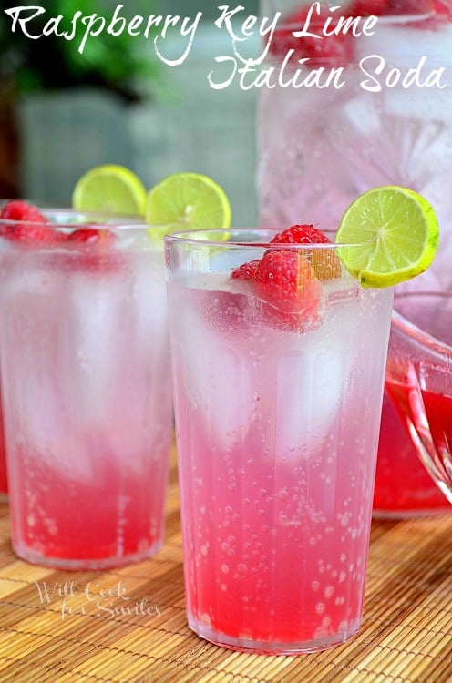 Raspberry Key Lime Italian Soda in a glass with lime and raspberries garnish 