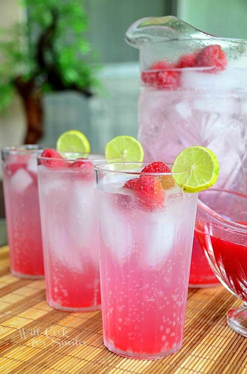 Raspberry Key Lime Italian Soda in a glass with lime and raspberries garnish 