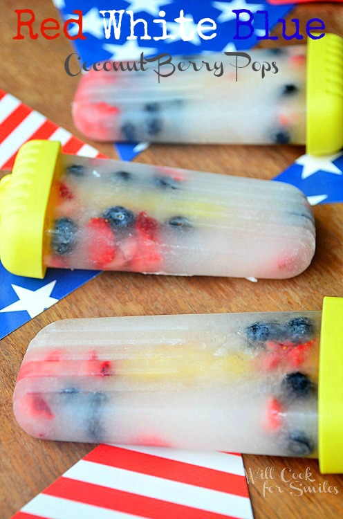 red white and blue ice pops on a wood table with red and white stripped flag and blue flag with stars 