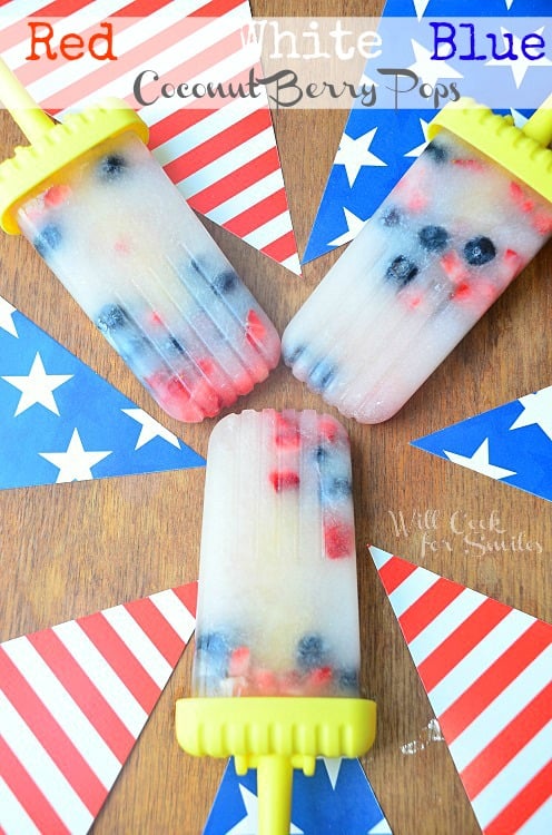 red white and blue ice pops on a wood table with red and white stripped flag and blue flag with stars 