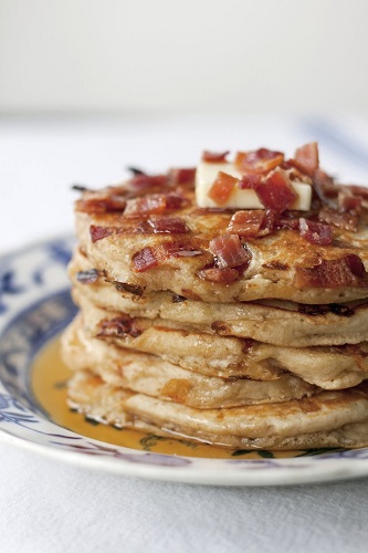 stack of bacon pancakes on white and blue china