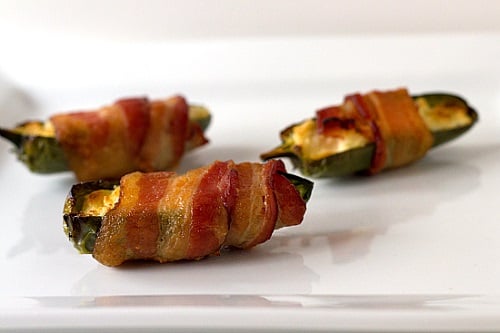 bacon wrapped jalapenos on a white plate 
