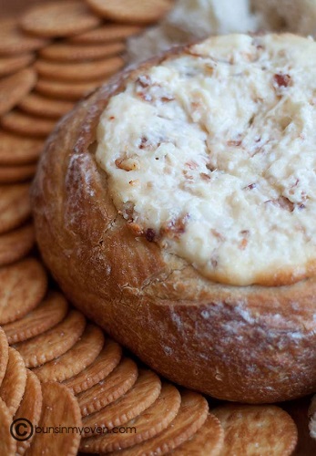 baked bread bowl cheese dip shot from above with crackers around bowl