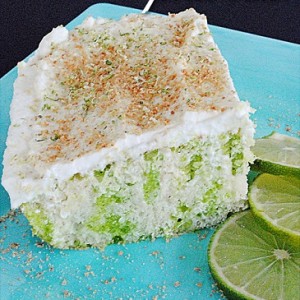 key lime poke cake slice on a plate with sliced lemons 