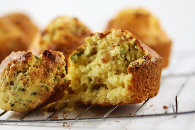 4 muffins on rack shot from front with foreground muffin broken into 2 pieces