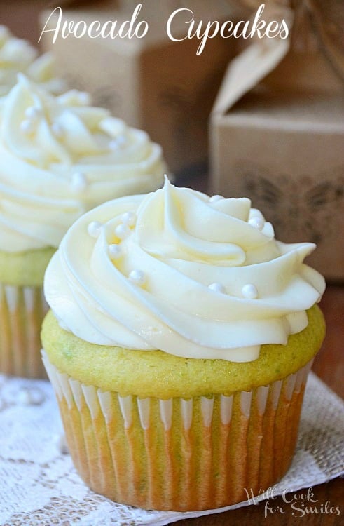 Cupcakes with white frosting and candy pearls on a lace paper 