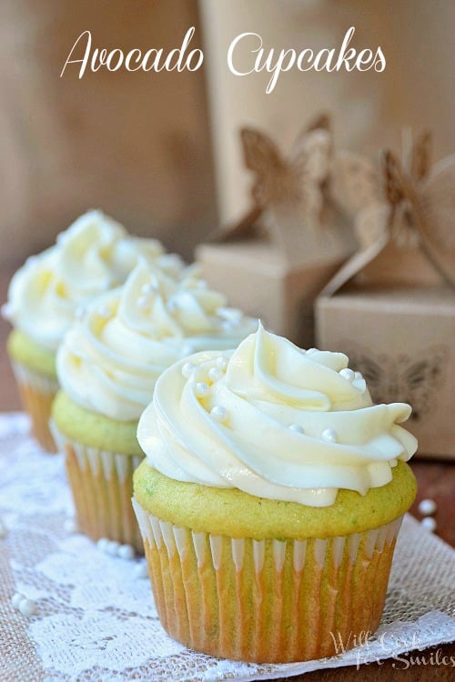 Cupcakes with white frosting and candy pearls on a lace paper 