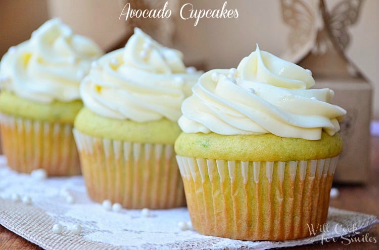 Cupcakes with white frosting and candy pearls on a lace paper 