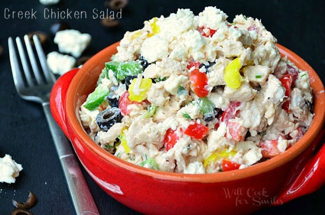 horizontal image of chicken salad in a bowl with a fork next to it and a few feta crumbs