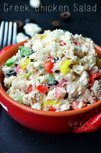 closer view of chicken salad in a red ceramic bowl with park of a fork visible