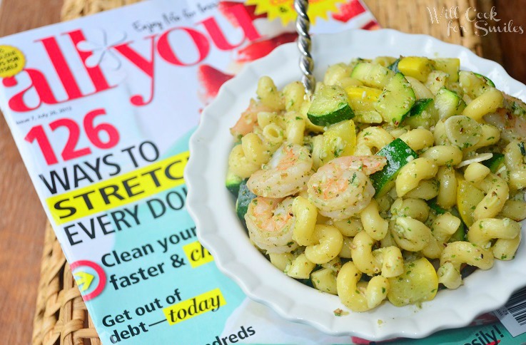 Shrimp and Veggie pesto Pasta Salad in a white bowl with the all you magazine under it 