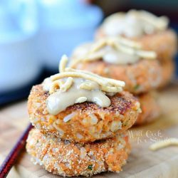 3 stacks of 2 salmon cakes each lined up on wooden cutting board with bamboo placemat below and chop sticks to left