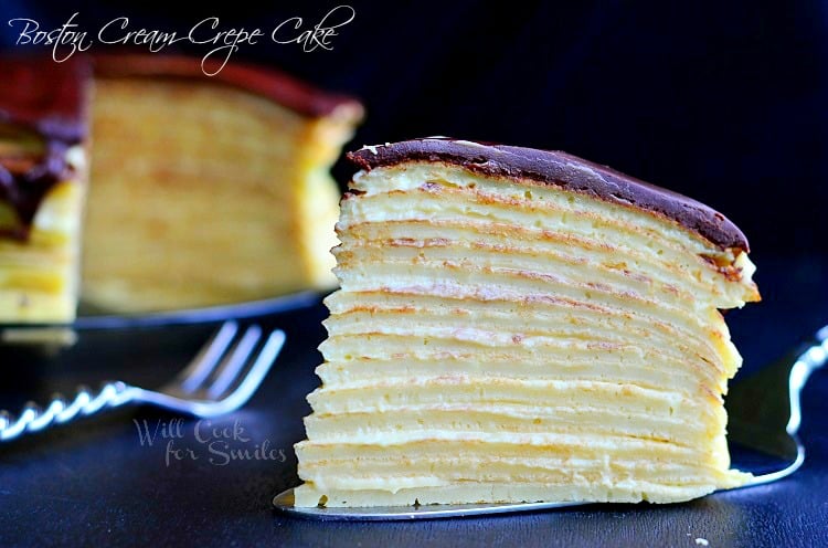 Boston Cream Crepe Cake slice on a cake cutter on a black counter top 