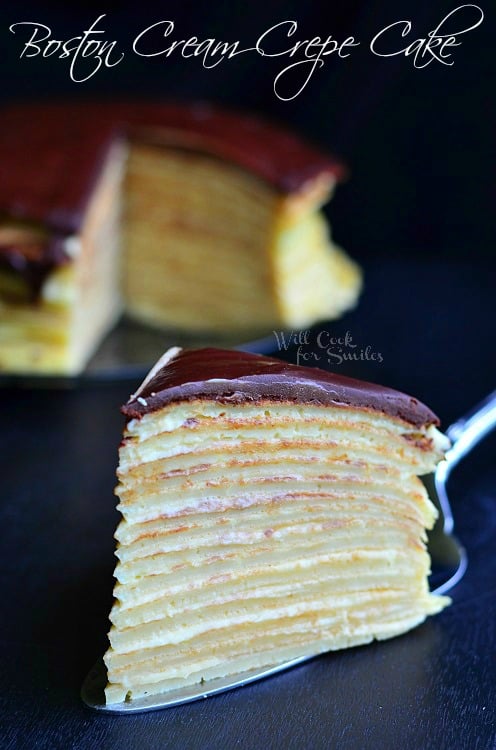 Boston Cream Crepe Cake slice on a cake cutter on a black counter top 