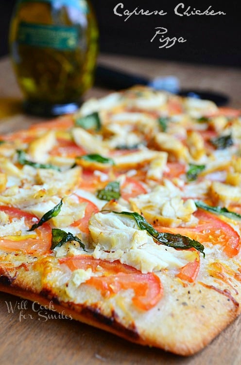 Caprese Chicken Pizza on a wood cutting board 