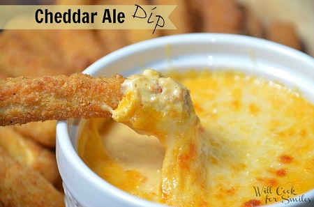 chicken fry being dipped into a Cheddar ale dip 