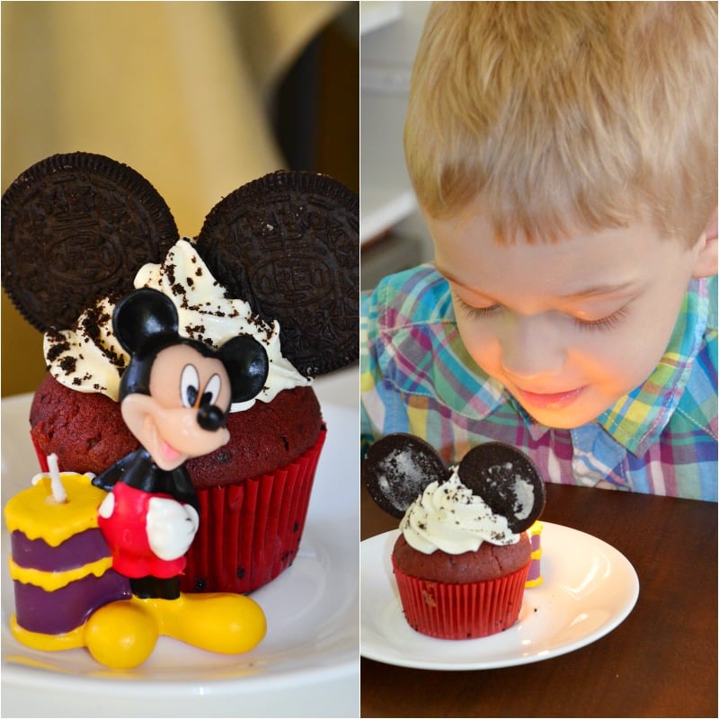 Red Velvet Oreo Cupcakes with white frosting and oreo crumbs sprinkled on top with oreos made to look like mickey ears, micky mouse candle 