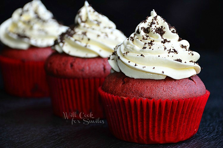 Red Velvet Oreo Cupcakes with white frosting and oreo crumbs sprinkled on top 