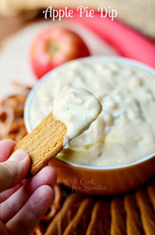 Apple Pie Dip in a bowl with a cookie scooping some dip up 