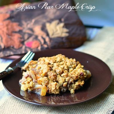 1 portion of Asian Pear crisp on black plate with fork at left all on burlap type placemat